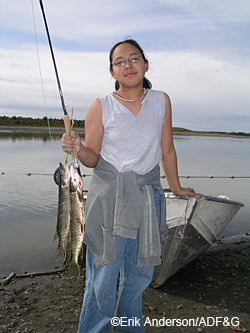 A Kalskag student shows her catch a pair of northern pike