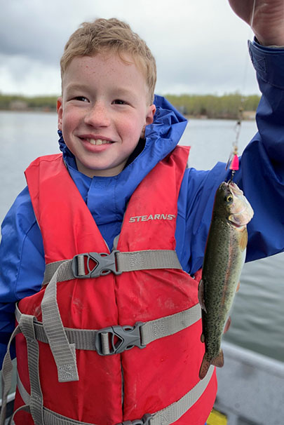 A young angler with a great looking stocked rainbow trout caught at Mirror Lake in Southcentral Alaska