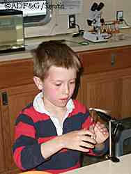 A young visitor to the mobile aquatic classroom in Sitka tries his hand at fly tying Photo by Tracy Smith