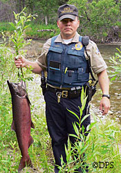 AWT Thomas Akelkok holds up king salmon he seized and turned over to charity after catching a boy fishing in waters only open to trout fishing