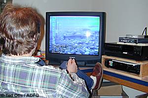 Fisheries technician Mark Dickson of Homer reviews images of migrating salmon recorded using a remote underwater camera installed in Delight Creek on the Kenai Peninsula