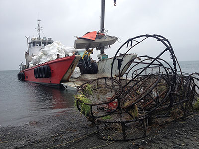 Loading the landing craft quotRetrieverquot with super sacks of marine debris A stack of derelict crab pots is staged for loading Photo courtesy Island Trails Network