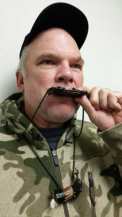 Blowing a deer call with a second home made call at hand