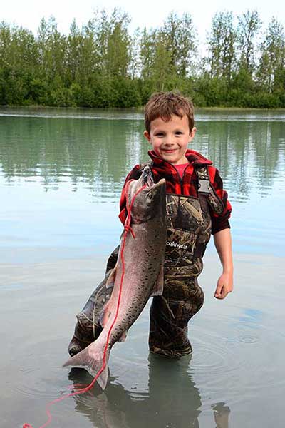 Proud young man with his first king salmon caught while fishing at the Eklutna TailracePhoto credit Jessica Hay