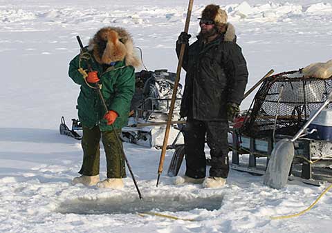 Crabbers use snow machines to cross sea ice and chainsaws to access the water in the winter Norton Sound crab fishery