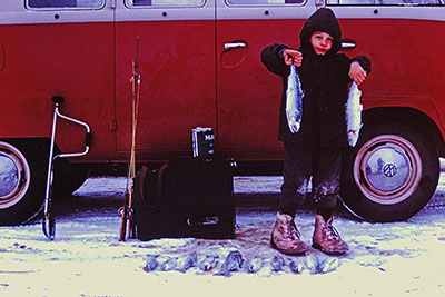 Probably cold and tired fiveyearold Clark Fair poses with some of the fish caught by him and his father on Scout Lake in 1963