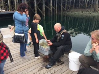 ADFampG diver Jeff Meucci shares a newly caught sea creature with a young Petersburg naturalist during the Diving For Science event in 2018 Photo by Sunny Rice Alaska Sea Grant Marine Advisory Program