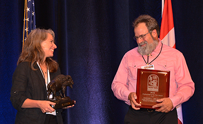 Dr Jennifer Psyllakis president of WAFWA presents Bruning with a bison statue as part of the awards ceremony in Oklahoma City in July 2022