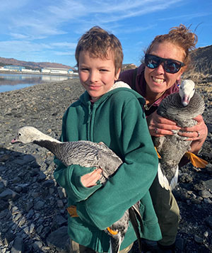 Tasha and volunteer Wesley with Emperor Geese